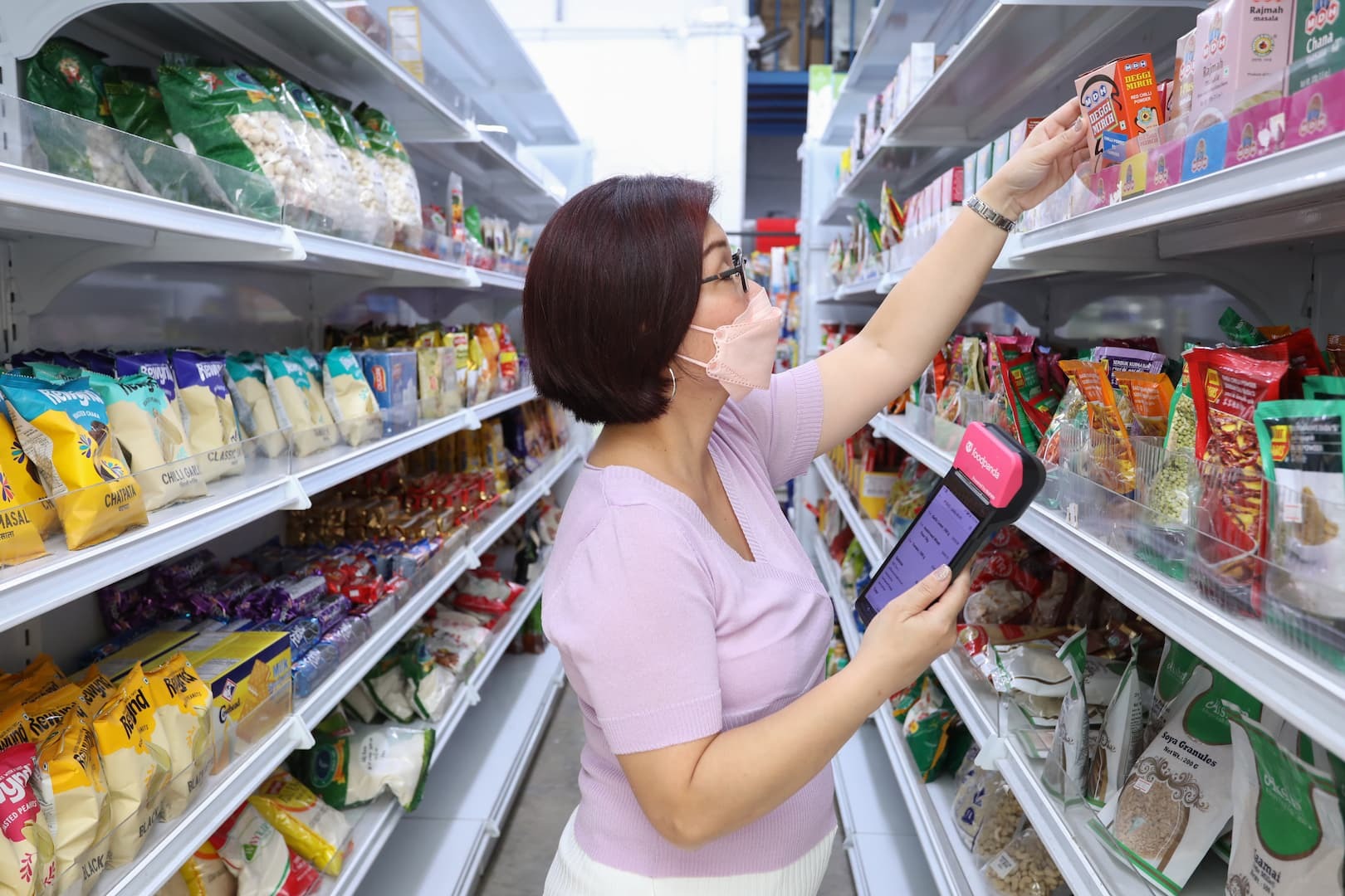 foodpanda delivery person handing over a food package to a customer